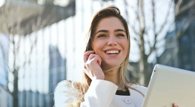 woman holding a tablet smiling 640×350